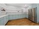 Large walk-in pantry with stainless steel refrigerator, open shelving, shaker cabinets, and wood flooring at 1306 Mordecai Dr, Raleigh, NC 27604
