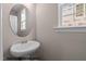Powder room with a modern round mirror and a pedestal sink at 133 Pearl St # 7, Garner, NC 27529