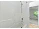 All-white bathroom features a bathtub with shower and built-in shelving at 13338 Ashford Park Dr, Raleigh, NC 27613