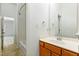 Bright bathroom featuring a shower-tub combo and a wooden vanity with a large mirror at 13338 Ashford Park Dr, Raleigh, NC 27613