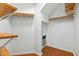 Walk-in closet with wood shelving and hardwood floors at 13338 Ashford Park Dr, Raleigh, NC 27613