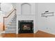 Close-up view of a marble fireplace with burning logs and stairs leading to the second floor at 13338 Ashford Park Dr, Raleigh, NC 27613