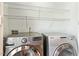 Laundry room with front load washer and dryer and wire shelving at 13338 Ashford Park Dr, Raleigh, NC 27613