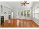 Sunlit living area with hardwood floors, a ceiling fan, and access to the backyard through a glass door at 13338 Ashford Park Dr, Raleigh, NC 27613