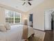 Bright bedroom featuring a large window, ceiling fan, and access to an ensuite bathroom and closet at 1605 Grace Point Rd, Morrisville, NC 27560