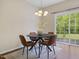 A dining area with a modern table, four chairs, and sliding doors to the outside at 1605 Grace Point Rd, Morrisville, NC 27560