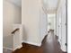 Upstairs hallway with hardwood floors, white trim, and natural light streaming in from the end bedroom at 1605 Grace Point Rd, Morrisville, NC 27560