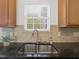 Close up of kitchen sink with granite countertops and a window view at 1605 Grace Point Rd, Morrisville, NC 27560