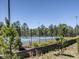 Community tennis court featuring a blue court surface and tall fencing surrounded by lush greenery at 1605 Grace Point Rd, Morrisville, NC 27560