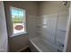 Bathroom with tiled shower/tub combination and a bright window at 172 Knoll Way, Sanford, NC 27332