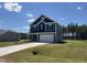 Well-manicured two-story home with blue siding, two car garage, and lush green lawn at 172 Knoll Way, Sanford, NC 27332