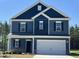 Inviting two-story home boasts blue siding, white trim, and a convenient two-car garage at 172 Knoll Way, Sanford, NC 27332