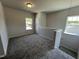 Upstairs loft with neutral walls, gray carpet, windows, and staircase view at 172 Knoll Way, Sanford, NC 27332