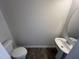 This powder room features a pedestal sink, gray walls, and wood-look floors at 172 Knoll Way, Sanford, NC 27332