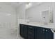 Bathroom featuring double sinks, dark blue cabinets and a shower and tub combo at 1724 Deacon Falls Way, Wendell, NC 27591