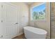 Modern bathroom with a standalone tub and a window view of the trees at 1724 Deacon Falls Way, Wendell, NC 27591