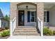 Inviting front porch with brick steps, white railings, and a dark wood front door at 1724 Deacon Falls Way, Wendell, NC 27591