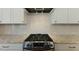 Close-up of the stove on an island with stainless steel hood at 1724 Deacon Falls Way, Wendell, NC 27591