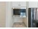 Close-up of the microwave with granite countertops and stainless steel fridge at 1724 Deacon Falls Way, Wendell, NC 27591