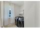 Laundry room equipped with modern washer and dryer, next to window with curtain at 1724 Deacon Falls Way, Wendell, NC 27591