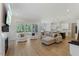 Open-concept living room with fireplace, sliding glass doors, and view of the kitchen at 1724 Deacon Falls Way, Wendell, NC 27591