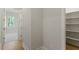 View of a doorway to a walk-in closet with white shelves and hardwood floors at 1724 Deacon Falls Way, Wendell, NC 27591