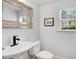 Neutral powder room featuring a decorative mirror, a black faucet, and a white toilet at 2008 Stanwood Dr, Apex, NC 27502