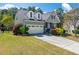 Charming home with a two-car garage, well-manicured lawn, and lovely landscaping under a blue sky at 2008 Stanwood Dr, Apex, NC 27502
