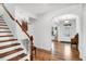 Open hallway featuring beautiful hardwood floors, a staircase with wooden railing, and neutral walls at 2008 Stanwood Dr, Apex, NC 27502