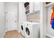 Bright laundry room with modern washer and dryer, built-in cabinets, and practical shelving at 2008 Stanwood Dr, Apex, NC 27502