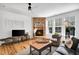Cozy living room has a stone fireplace, hardwood floors, large windows, and neutral decor at 2008 Stanwood Dr, Apex, NC 27502