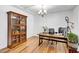 Bright home office featuring hardwood flooring, a wooden bookcase, and an ample-sized desk at 2008 Stanwood Dr, Apex, NC 27502