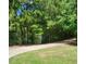 Pathway lined by trees and grass with a sign visible in the distance, enhancing the community's landscape at 2008 Stanwood Dr, Apex, NC 27502