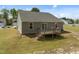 Scenic backyard featuring a wooden deck with stairs and a spacious lawn, ideal for outdoor activities at 2040 Alderman Way, Creedmoor, NC 27522