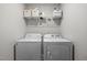 Functional laundry area with washer, dryer, and shelving for storage, providing convenience at 2040 Alderman Way, Creedmoor, NC 27522