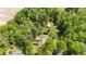 Aerial view showcasing the property with a home, outbuildings, lush greenery, and mature trees, emphasizing seclusion at 209 Pen Lou Ct, Angier, NC 27501