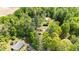 Aerial view of property featuring a home, outbuildings, lush greenery, and mature trees, providing a sense of privacy at 209 Pen Lou Ct, Angier, NC 27501