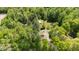 Aerial view of property featuring a home, outbuildings, lush greenery, and mature trees, providing a sense of privacy at 209 Pen Lou Ct, Angier, NC 27501