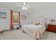 Cozy bedroom with a tufted headboard, complemented by a ceiling fan and warm natural light at 209 Pen Lou Ct, Angier, NC 27501