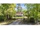 Charming home with a inviting front porch surrounded by mature trees and lush greenery, creating a private retreat at 209 Pen Lou Ct, Angier, NC 27501