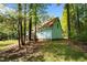 Side view of home displaying the architectural style with a well-maintained lawn and surrounding trees at 209 Pen Lou Ct, Angier, NC 27501