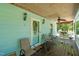 Relaxing covered porch with wood flooring, ceiling fan, and ample seating at 209 Pen Lou Ct, Angier, NC 27501
