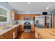 A bright kitchen with wooden cabinets and stainless steel appliances, including a microwave, oven, and refrigerator at 209 Pen Lou Ct, Angier, NC 27501