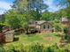 Large backyard featuring a wooden deck, storage shed, garden plot, and mature landscaping at 2211 Hillock Dr, Raleigh, NC 27612