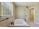 Bright bathroom featuring a jacuzzi tub with tile surround, next to a window and open door to walk-in closet at 2211 Hillock Dr, Raleigh, NC 27612