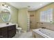 Well-lit bathroom featuring a jacuzzi tub, glass block shower, and dark wood vanity at 2211 Hillock Dr, Raleigh, NC 27612