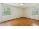 Bedroom featuring hardwood floors and natural light from the two windows at 2211 Hillock Dr, Raleigh, NC 27612