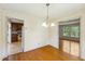 Dining room with hardwood floors, a chandelier, and doorways leading to the kitchen and living spaces at 2211 Hillock Dr, Raleigh, NC 27612