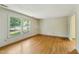 Sunlit living room featuring hardwood floors, a large window, and neutral wall colors offers a bright and airy space at 2211 Hillock Dr, Raleigh, NC 27612