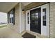 Close-up of the front door with sidelights, showcasing the brick facade and exterior lighting at 226 Fair Oaks Ct, Mebane, NC 27302